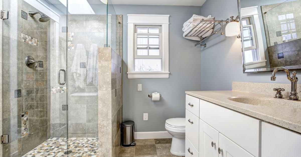 A pristine residential bathroom featuring a spotless walk-in tiled shower with completely clear, streak-free glass enclosure doors, demonstrating the ultimate goal of preventing stubborn soap scum film.