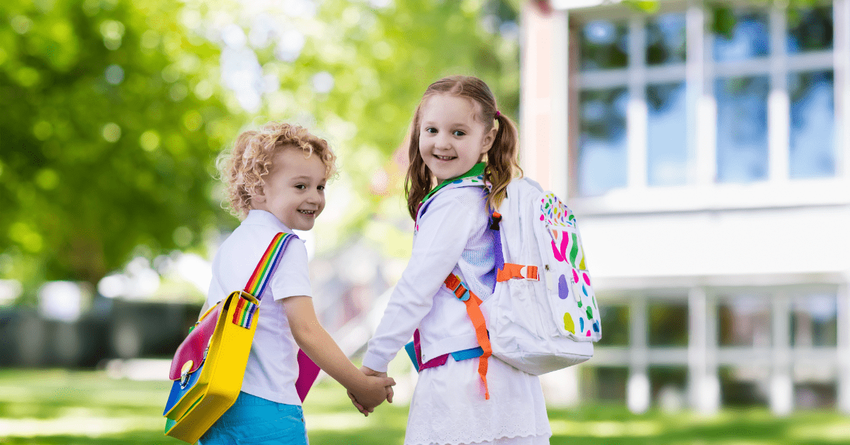 Two young children with backpacks heading to school illustrating tips for preparing your home for a successful new school year