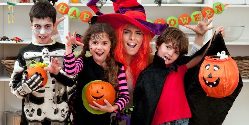 Family in Halloween costumes celebrating at home illustrating the need for post-Halloween cleanup tips from C's Home & Office Management